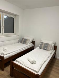 dwa łóżka pojedyncze w pokoju z oknem w obiekcie Motel S7 w mieście Goszczyn