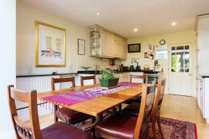 een keuken en eetkamer met een houten tafel en stoelen bij Veeve - Clareville Classic in Londen