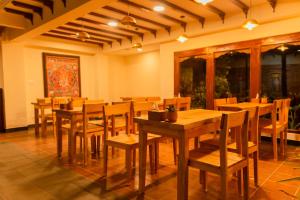 una sala da pranzo con tavoli e sedie in legno di KGH Patan a Patan