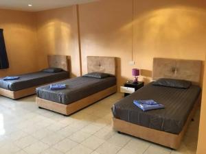 3 camas sentadas en una habitación con en Khaolak inn, en Khao Lak