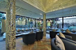 a restaurant with black chairs and a gold ceiling at Sawasdee Village in Kata Beach