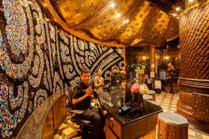 a man sitting at a bar in a salon at Sawasdee Village in Kata Beach