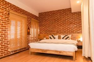 Schlafzimmer mit Ziegelwand und Bett in der Unterkunft KGH Patan in Pātan