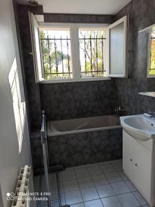 y baño con bañera y lavamanos. en Chambre d hôte à 20 min de VERSAILLES, en Le Mesnil-Saint-Denis