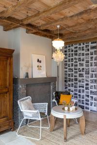 - un salon avec une table, des chaises et une cheminée dans l'établissement Het Verblijf, à Sint-Martens-Lennik