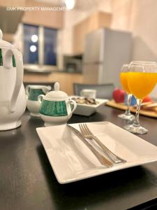 a table with a plate and a glass of orange juice at City Flats Apt.C307 in Larnaca