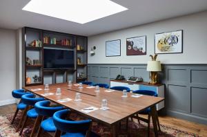 a conference room with a large wooden table and blue chairs at Hotel Indigo - Stratford Upon Avon, an IHG Hotel in Stratford-upon-Avon