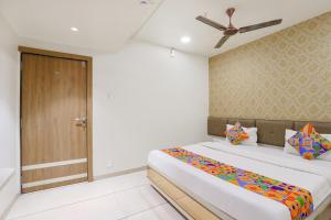 1 dormitorio con 1 cama y ventilador de techo en FabHotel Bharosa Inn en Ahmedabad