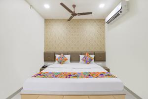 a bed in a room with a ceiling fan at FabHotel Bharosa Inn in Ahmedabad
