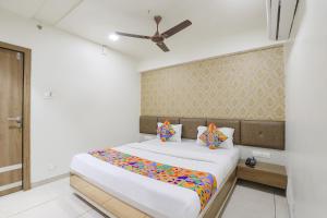 a bedroom with a bed and a ceiling fan at FabHotel Bharosa Inn in Ahmedabad