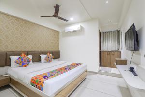 a bedroom with a large bed and a television at FabHotel Bharosa Inn in Ahmedabad