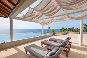 a patio with a view of a swimming pool at Ayara Villa 3 - Unique Gem with Private Pool and Majestic Sea Views in Amphoe Thalang