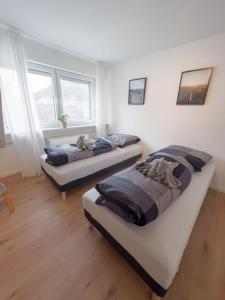 two beds in a room with two windows at 3-Zimmer Apartment 88 qm bis zu 8 Personen in Winningen