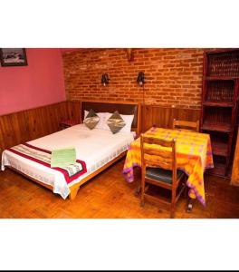 - une chambre avec un lit et une table dans l'établissement Shiva Guest House 2, à Bhaktapur