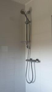 a shower with a shower head on a wall at 2 Bedroom, free parking & Netflix near hospitals in Aberdeen