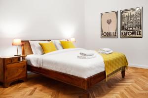 1 dormitorio con 1 cama grande con almohadas amarillas en HOUSEHOST Apartment :Starowiślna 66/9 Street en Cracovia