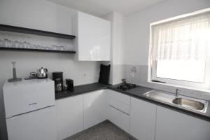 a white kitchen with a sink and a window at Apartment Milijana in Punat