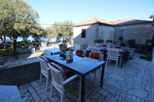 a patio with tables and chairs on a stone patio at Apartment Milijana in Punat