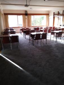an empty room with tables and chairs and windows at Ravenswood Social Club in Banchory
