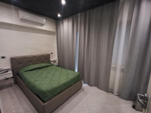 1 dormitorio con 1 cama con manta verde en B&B Rossini Luxury, en Rende