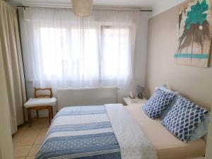 sypialnia z łóżkiem, krzesłem i oknem w obiekcie Bienvenue chez vous ! Malo (3mn de la plage) w mieście Dunkierka