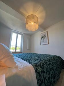 a bedroom with a bed and a light fixture at Oasis de 42 m2 I Cosy I Cœur de ville I Lit 160x200 in Vaison-la-Romaine