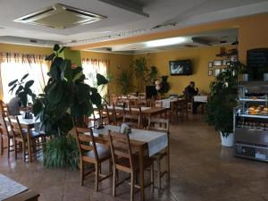 jadalnia ze stołami, krzesłami i roślinami w obiekcie Motel S7 w mieście Goszczyn