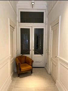 a room with a chair in front of a door at De Cosy Barock met gezellige Patio ! in Breda