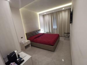 um pequeno quarto com uma cama vermelha num quarto em B&B Rossini Luxury em Rende