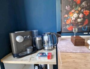 De Cosy Barock met gezellige Patio ! في بريدا: آلة صنع القهوة على طاولة خشبية في الغرفة