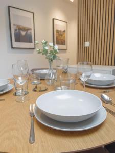 een houten tafel met een witte plaat en wijnglazen bij 2-Zimmer Apartment 52 qm bis zu 4 Personen in Winningen