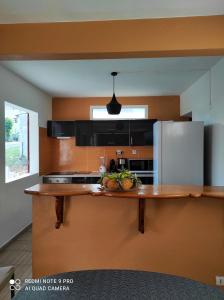 a kitchen with a counter top with a refrigerator at Appartement de 3 chambres a Le Moule a 800 m de la plage avec piscine partagee et jardin clos in Le Moule