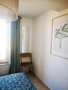 a bedroom with a bed and a chair and a window at Oasis de 42 m2 I Cosy I Cœur de ville I Lit 160x200 in Vaison-la-Romaine
