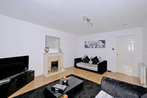 sala de estar con sofá y chimenea en Orange Apartments Beechgrove Gardens, en Aberdeen