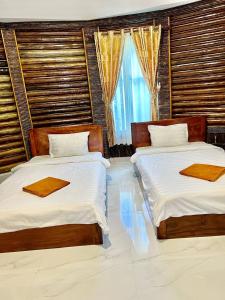 een slaapkamer met 2 bedden en een raam bij M'pay Bay Guesthouse in Koh Rong Sanloem