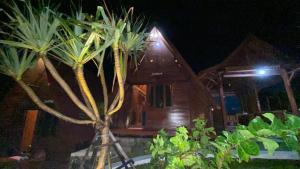 une maison avec un palmier en face de celle-ci dans l'établissement Sandhya Giri Beach Resort, à Brono