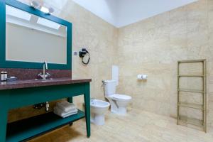 une salle de bain avec toilettes, lavabo et miroir dans l'établissement 1898 Suite, à Varsovie