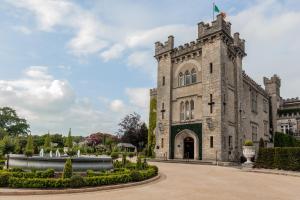 an old building with a flag on top of it at Cabra Castle Hotel in Kingscourt