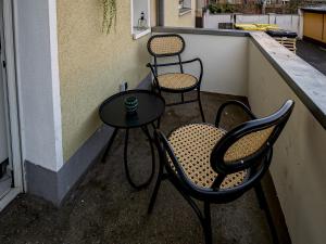 3 Stühle und ein Tisch auf dem Balkon in der Unterkunft JUNIK Apartments "Am Sternbuschweg" in Duisburg