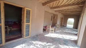 una stanza con porta e tavolo e sedie di Dar Paru a M'Hamid