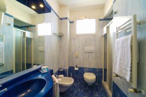 ein Badezimmer mit einem blauen Waschbecken und einem WC in der Unterkunft Hotel Imperial Beach - Dada Hotels in Rimini