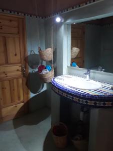 bagno con lavandino e specchio di Dar Paru a M'Hamid