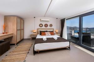 ein Schlafzimmer mit großem Bett und großem Fenster in der Unterkunft Villa Pırlanta, Kalkanvilla in Kalkan + 37 Fotos