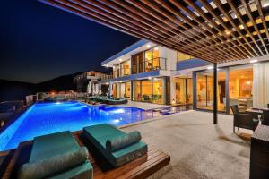 ein großes Haus mit einem Swimmingpool bei Nacht in der Unterkunft Villa Pırlanta, Kalkanvilla in Kalkan