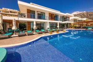 ein großes Schwimmbad vor einem Haus in der Unterkunft Villa Pırlanta, Kalkanvilla in Kalkan