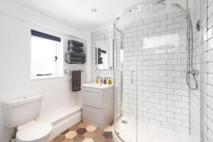 a white bathroom with a shower and a toilet at The Old Parsonage in Farrington Gurney
