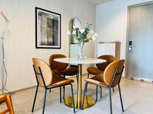 a dining room with a table and chairs and a mirror at Asok - Din Daeng Apartment in Bangkok