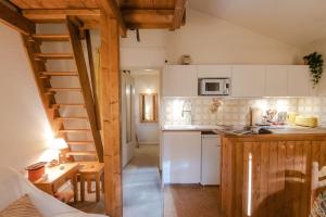 uma cozinha com armários brancos e uma escada de madeira em Charming apartment in Praz de Chamonix em Chamonix-Mont-Blanc