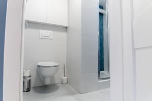 een witte badkamer met een toilet en een douche bij Miłe studio z ogródkiem i osobnym wejsciem in Radom