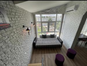 um quarto com um sofá e uma parede de tijolos em Big and comfortable apartment em Chisinau
